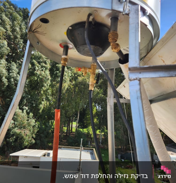 חיבורים וצינורות מתחת לדוד שמש על גג